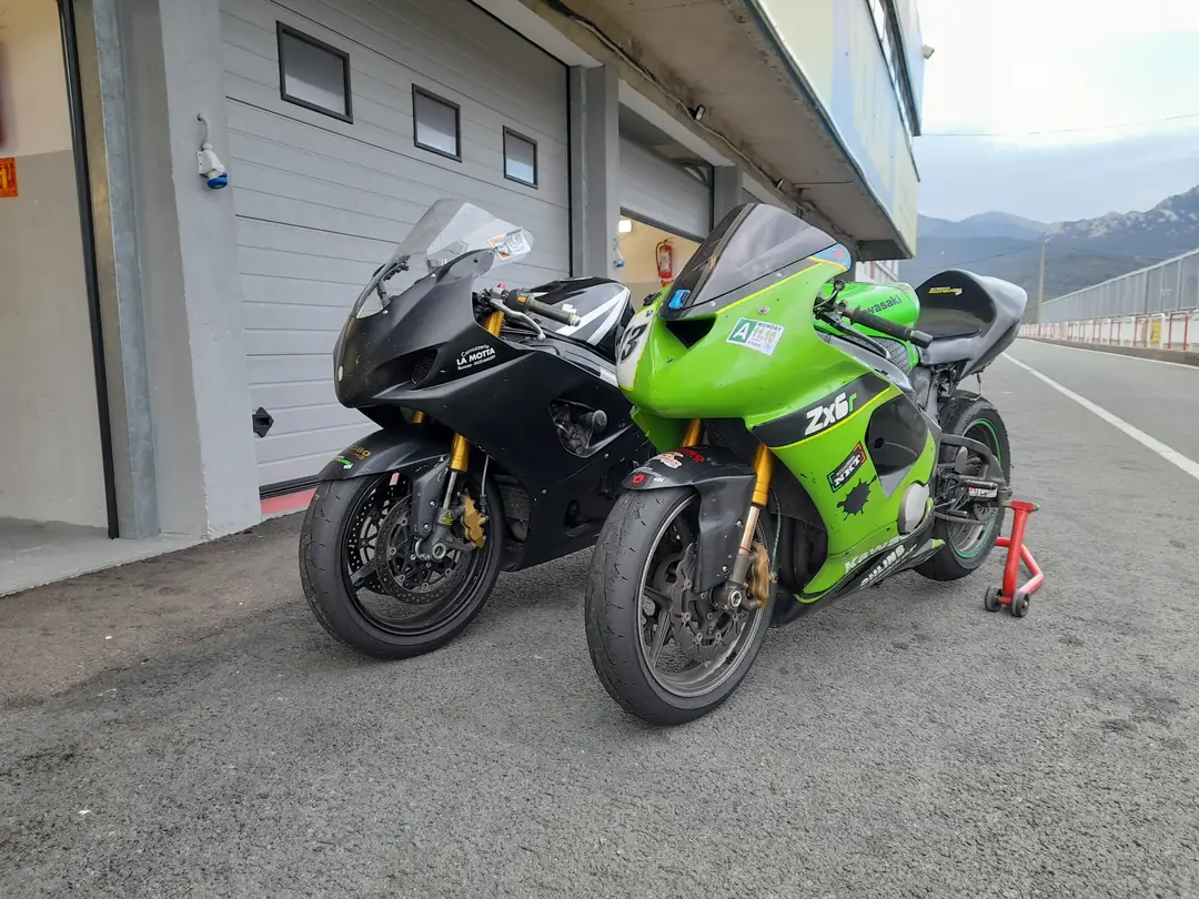 Due moto sportive sui cavalletti nella corsia dei box di un circuito